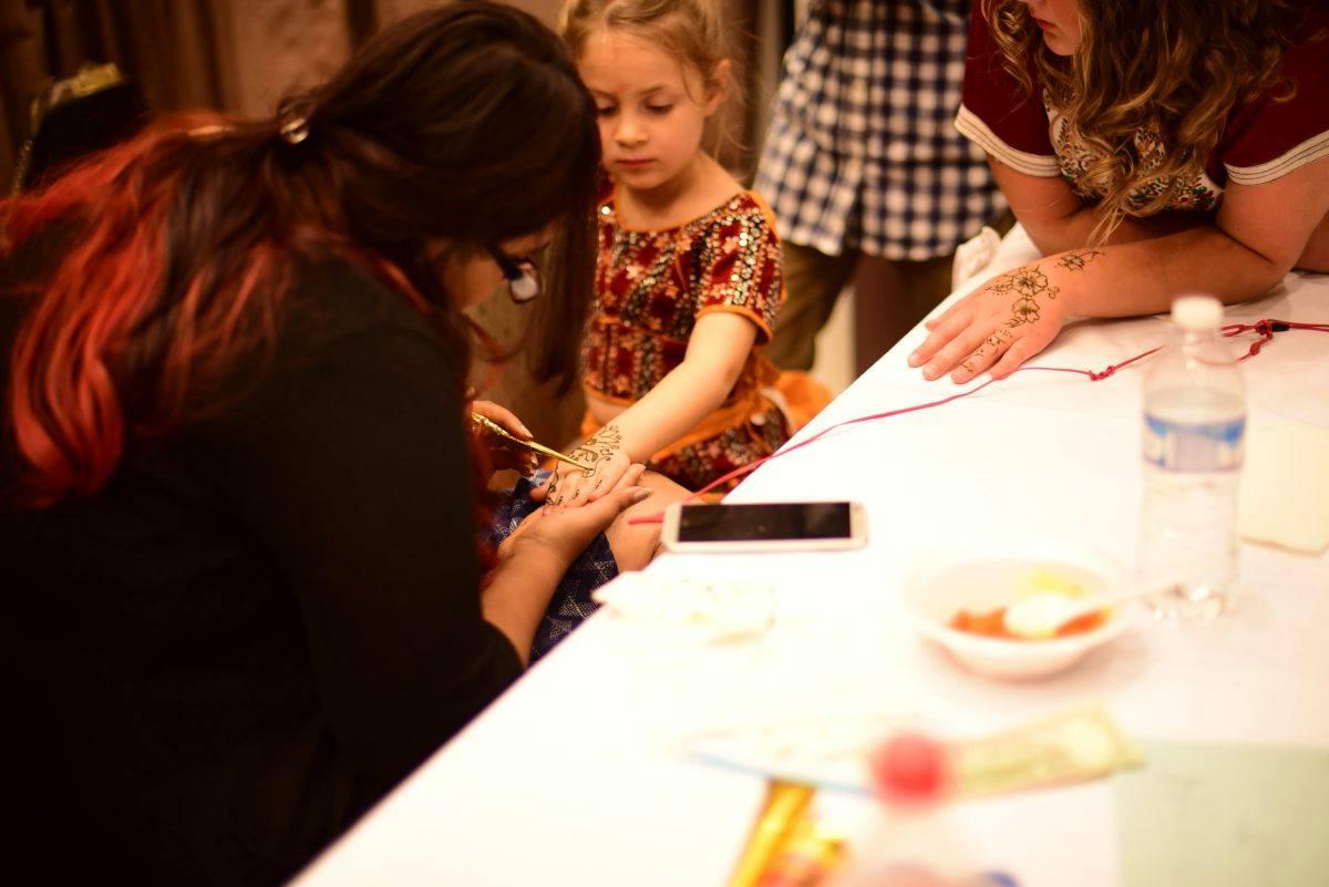 Young girl getting henna tattoo done at the Indo-American Friendship Day Celebration